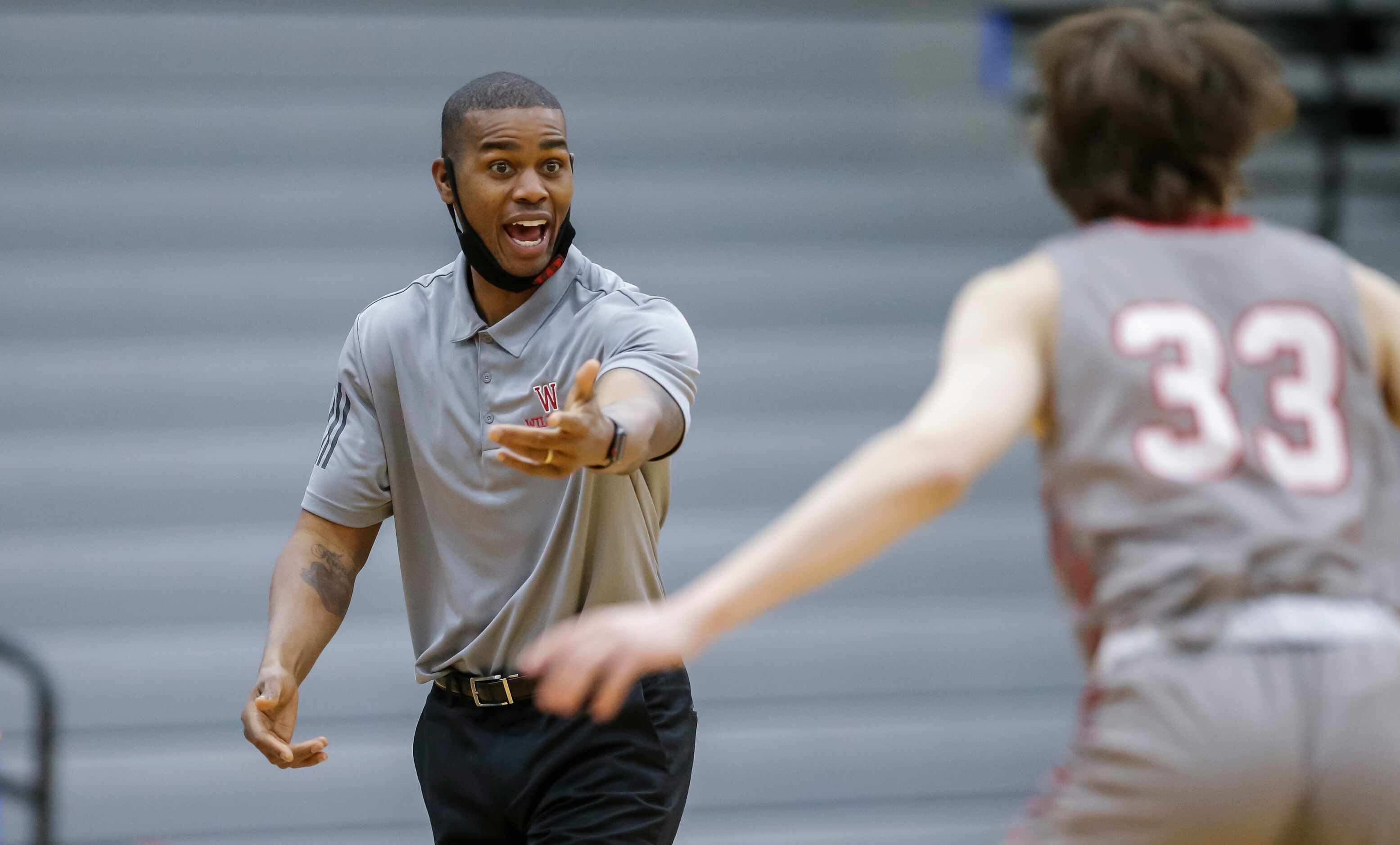 Woodrow Wilson coach Corey Johnson shouts instructions to junior guard Reid Blackmon during...