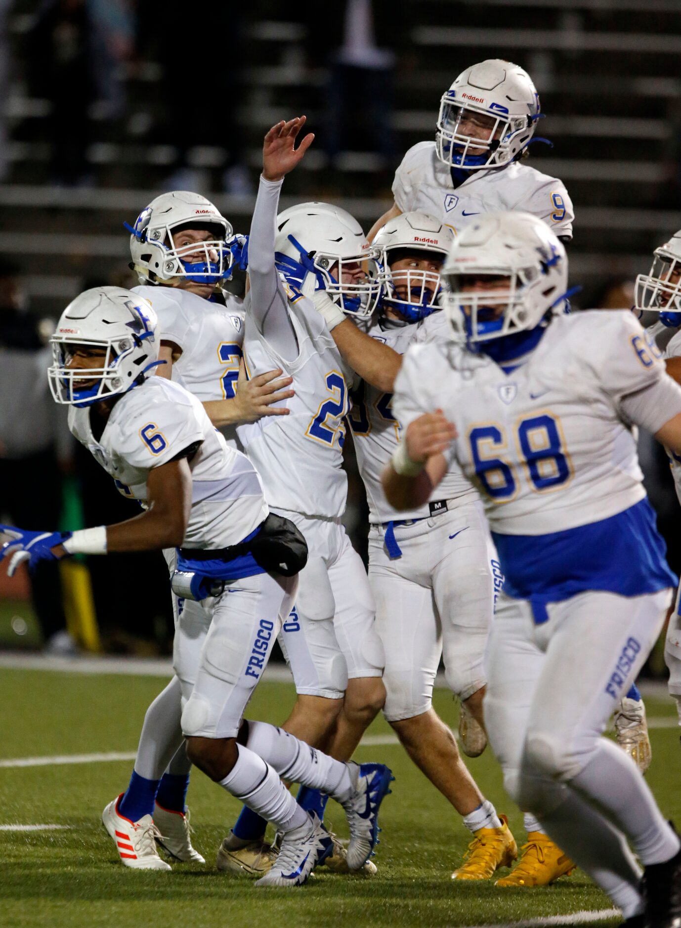 Frisco freshman kicker Mason Stallons (29, third from left) is mobbed by teammates and they...