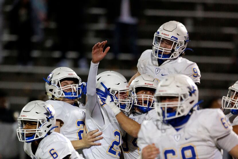 Frisco freshman kicker Mason Stallons (29, third from left) is mobbed by teammates and they...