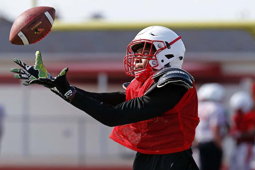 Wide receiver Kennedy Lewis makes a catch during football practice for Melissa High School...