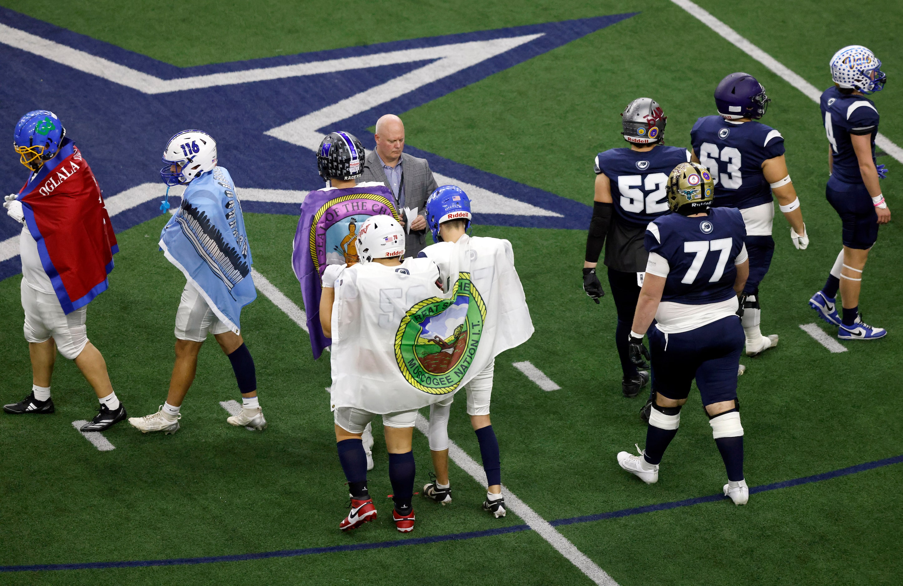 Members of the Ta’ Tanka select football team carry their flags as they are introduced...