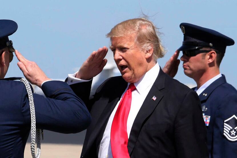 President Donald Trump salutes a U.S. Air Force security detail at Orlando International...