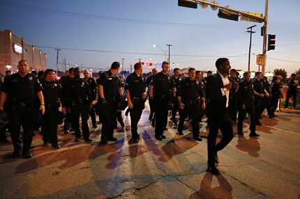 Dallas police officers formed a line as they tried to move protesters down Cadiz Street...
