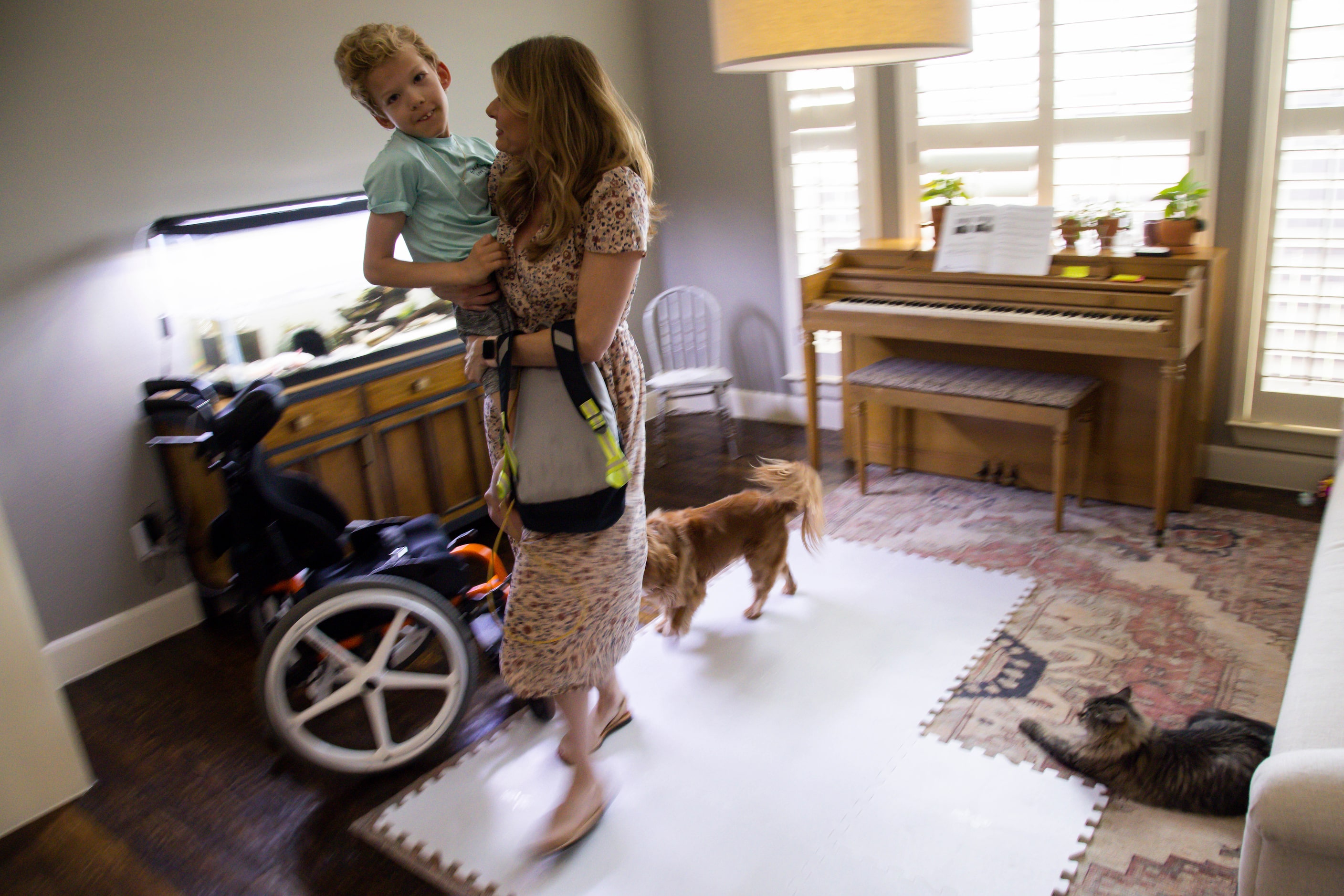 Kasey Woleben, 11, prepares to take Will Woleben upstairs at their home in McKinney on...