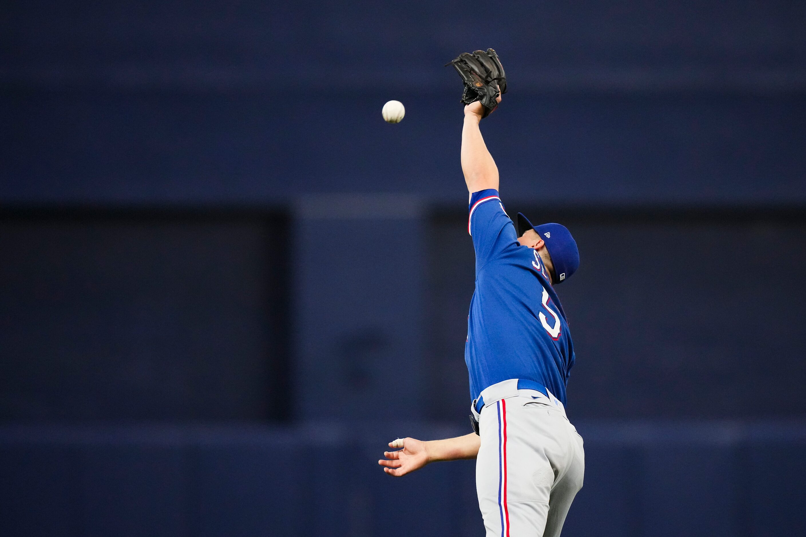 Texas Rangers shortstop Corey Seager can’t make a leaping catch on a single off the bat of...