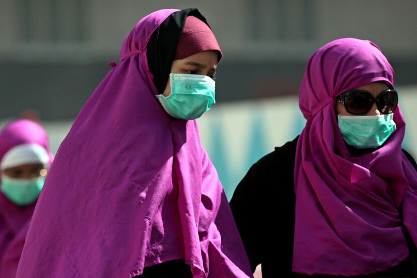 Muslim pilgrims wear surgical masks to prevent infection from respiratory virus MERS in the...