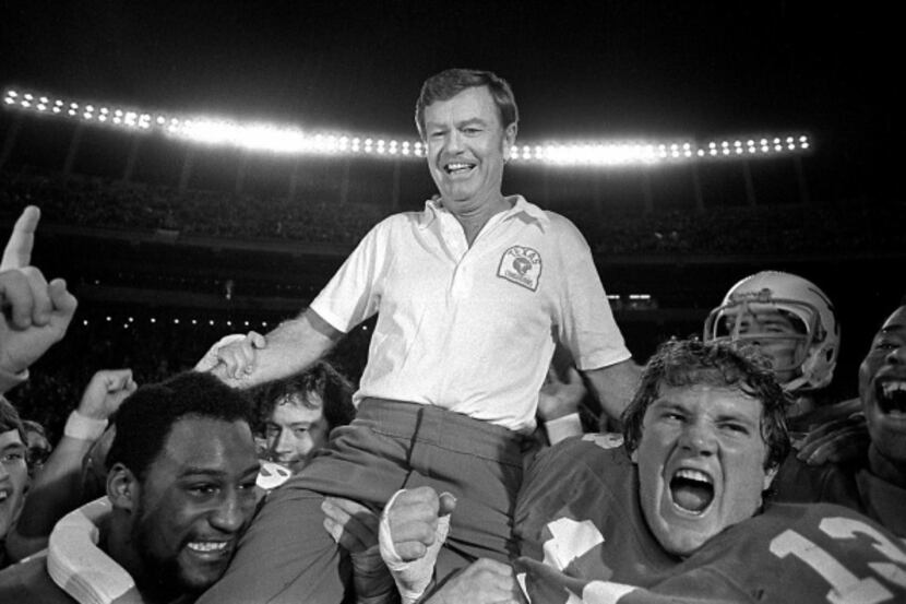 University of Texas Football coach Darrell Royal is carried from the football field...