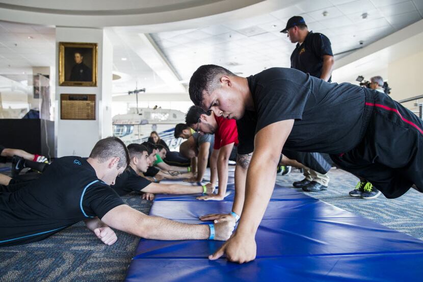 Dallas police applicants Ross Harbor (left) and Tony Hinojosa (right)  do pushups while...
