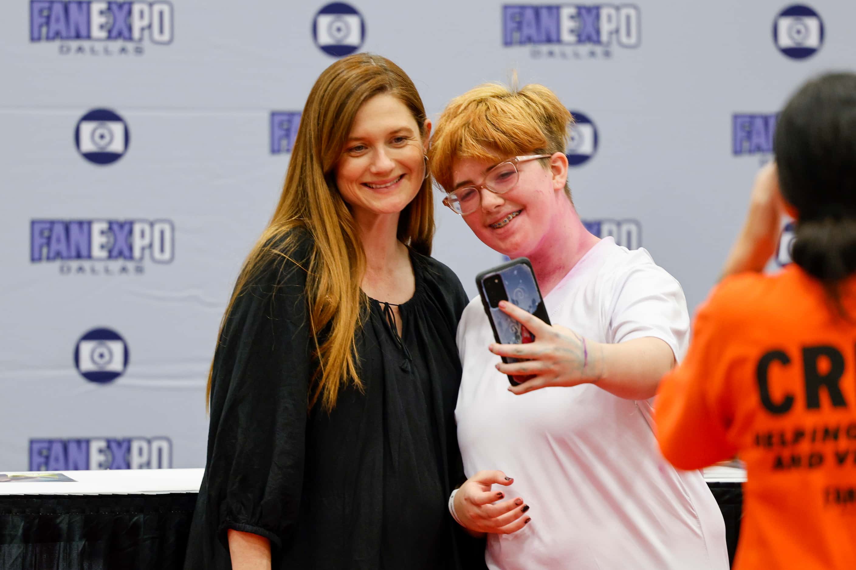 Actress Bonnie Wright (left) poses for a selfie with a fan at Fan Expo Dallas at the Kay...