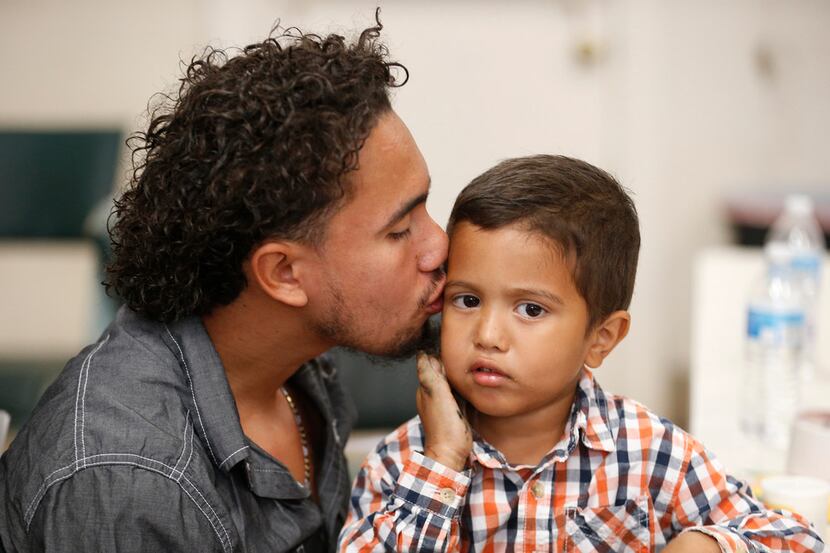 Roger Ardino 24, gives his son Roger Ardino Jr., 4, a kiss on the cheek shortly after...
