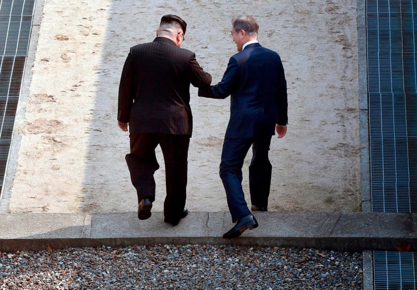 North Korean leader Kim Jong Un, left, and South Korean President Moon Jae-in cross the...