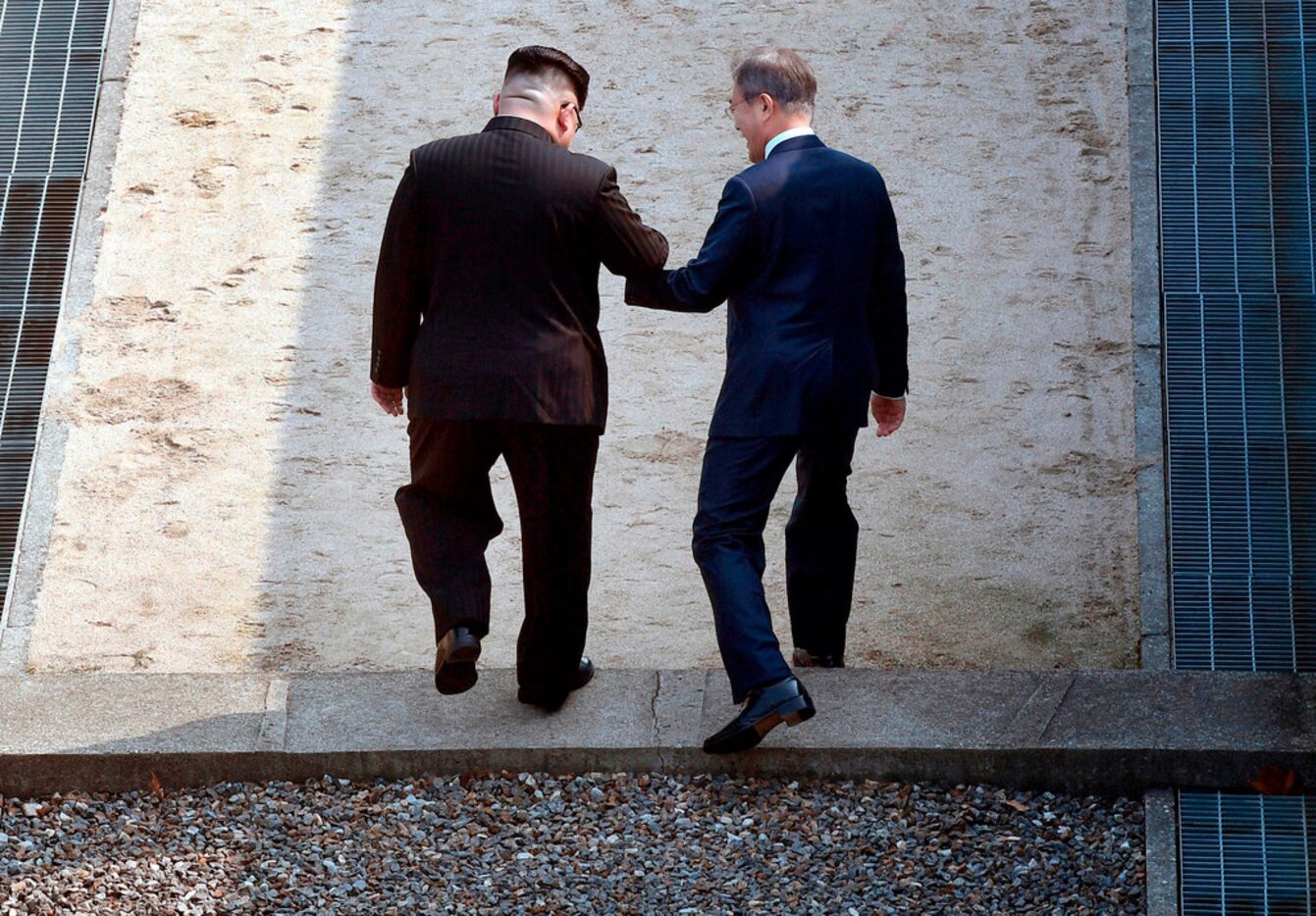 North Korean leader Kim Jong Un, left, and South Korean President Moon Jae-in cross the...