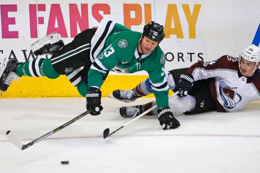 Dallas Stars defenseman Marc Methot (33) fights for the puck along the boards with Colorado...