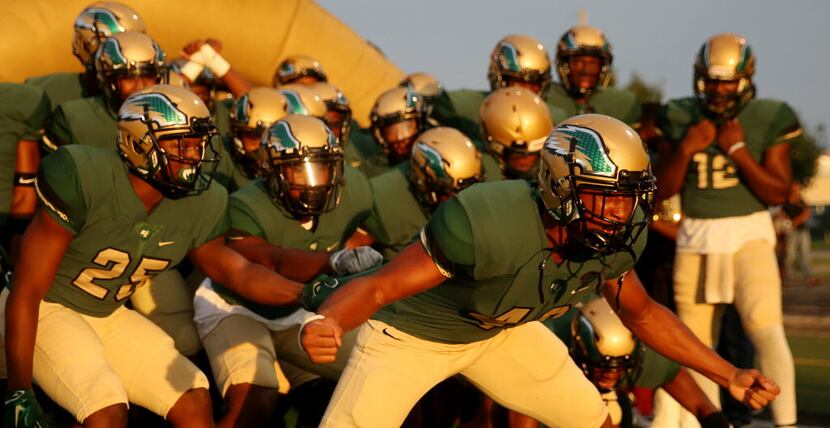 DeSoto players prepare to run onto the field before a high school football game between...