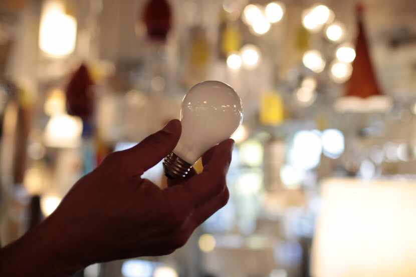 FILE - In this Jan. 21, 2011 file photo, manager Nick Reynoza holds a 100-watt incandescent...
