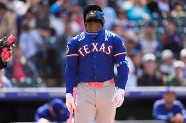 Texas Rangers' Adolis García reacts after popping out against Colorado Rockies relief...