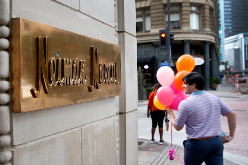 A man with balloons passes by the Neiman Marcus downtown Dallas store on Friday, September...