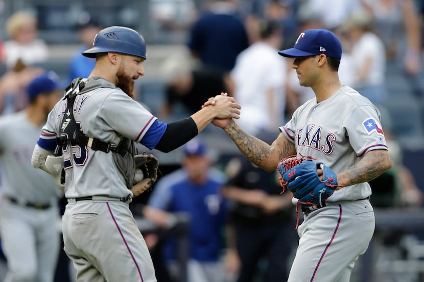Texas Rangers relief pitcher Matt Bush, right, and catcher Jonathan Lucroy celebrate after...