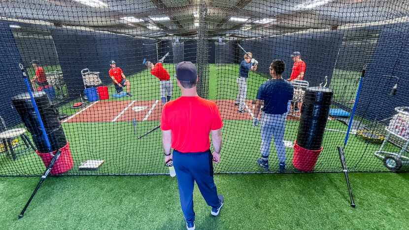 Dallas Baptist University baseball head coach Dan Heefner, center, watches as his players...