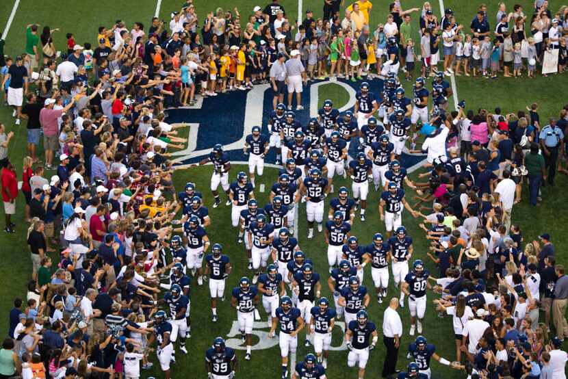 ORG XMIT: 323920 The Rice Owls run into the stadium through a crowd of fans before playing...