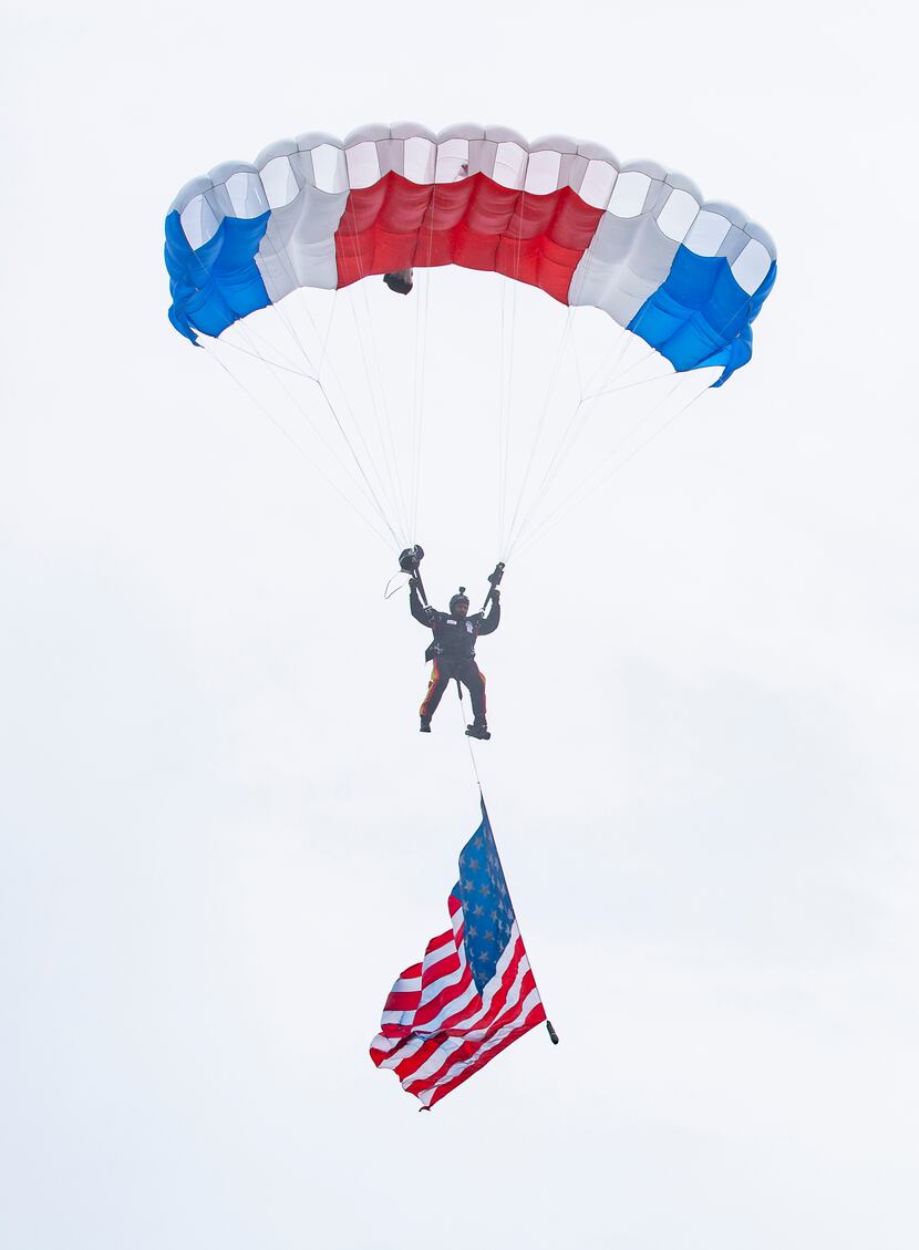 President of the All Veteran Group Mike Elliott parachutes with an American flag as part of...