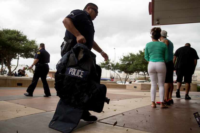 Un agente de la Policía de Dallas toma equipamiento para situaciones tácticas afuera del...