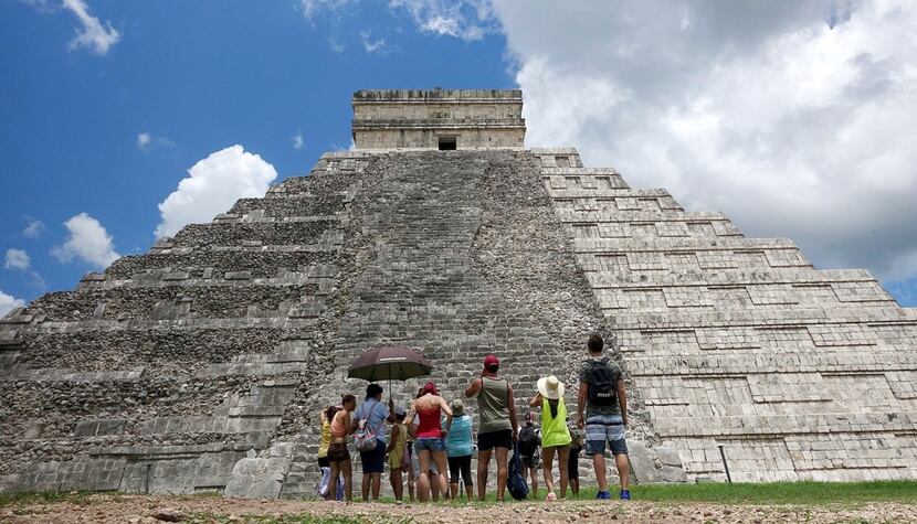 Tourists are dwarfed by El Castillo at the Chichen-Itza ruins in Yucatan, Mexico. While...