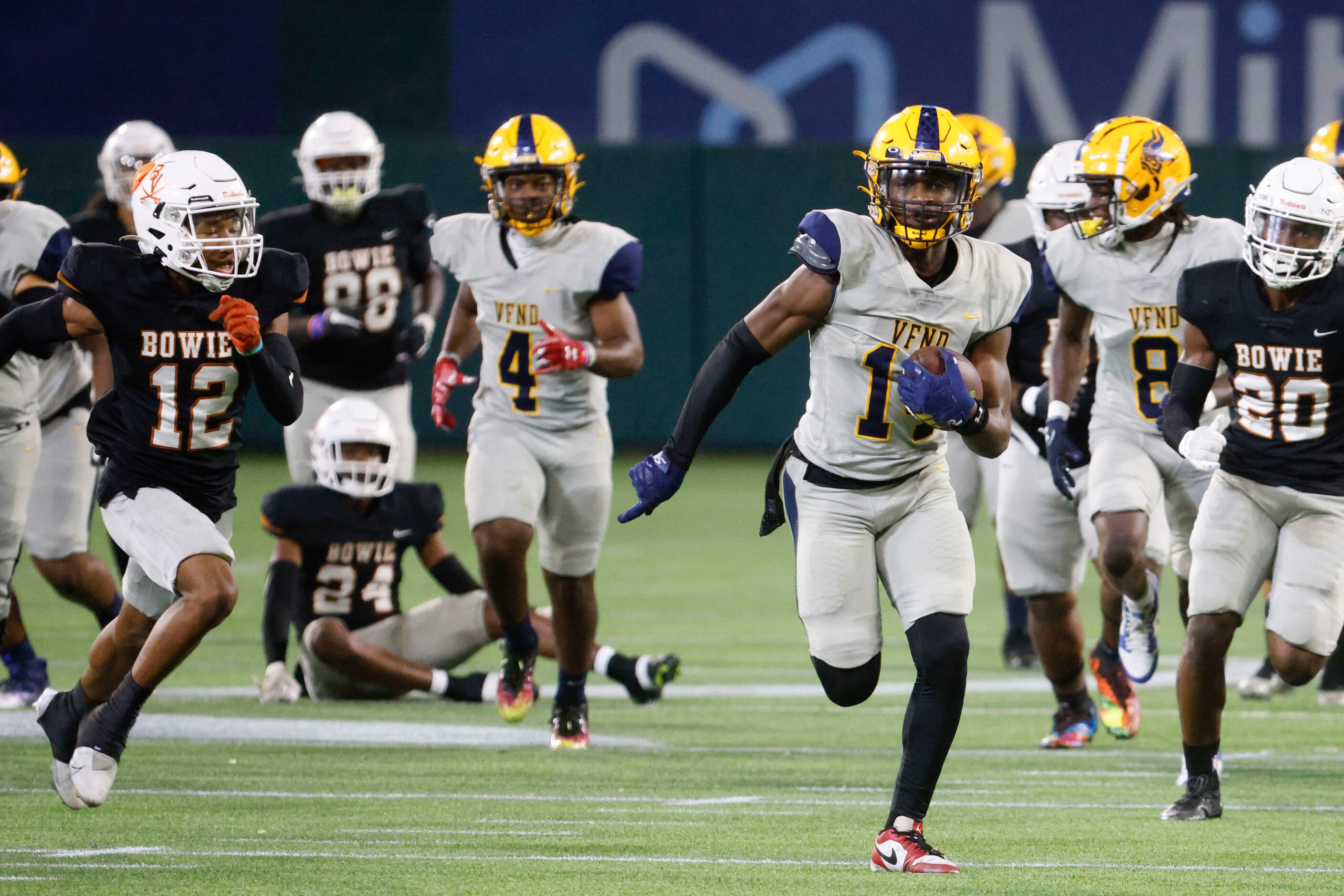 Lamar High’s Trenton Yancey (center right) runs past James Bowie High’s Jordan Patterson...