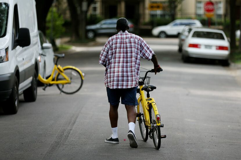 Maurice Clark, a "rebalance technician" with bike-share company Ofo, rebalances bikes along...