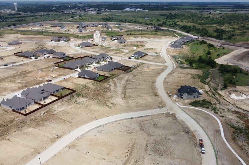 Rooftops start to rise in the first phase of the 3,150-acre Reunion community between Rhome...