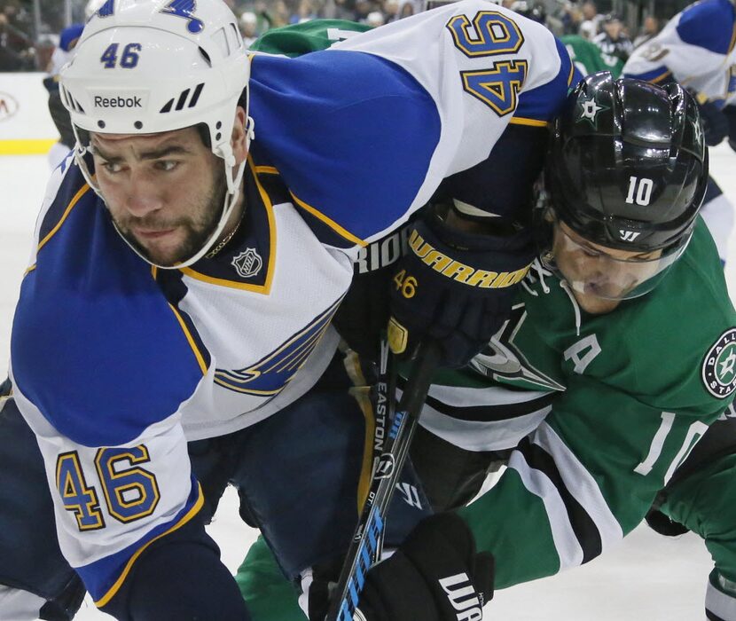 Dallas' Shawn Horcoff (10) and St. Louis' Roman Polak (46) get tangled up in the first...