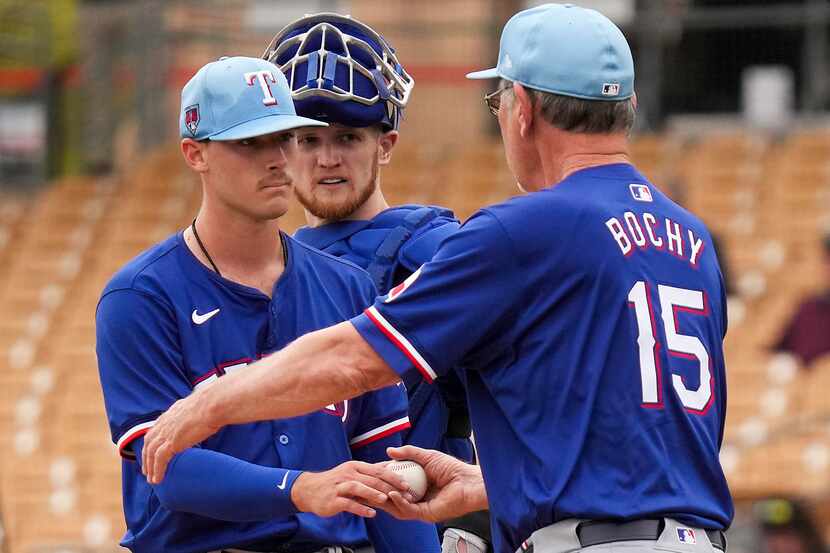 Texas Rangers pitcher Cole Winn hands the ball to manager Bruce Bochy as he leaves the game...