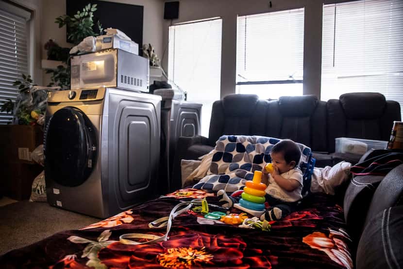 Juan González Jr, juega con sus juguetes en la sala de su apartamento que su madre improvisó...