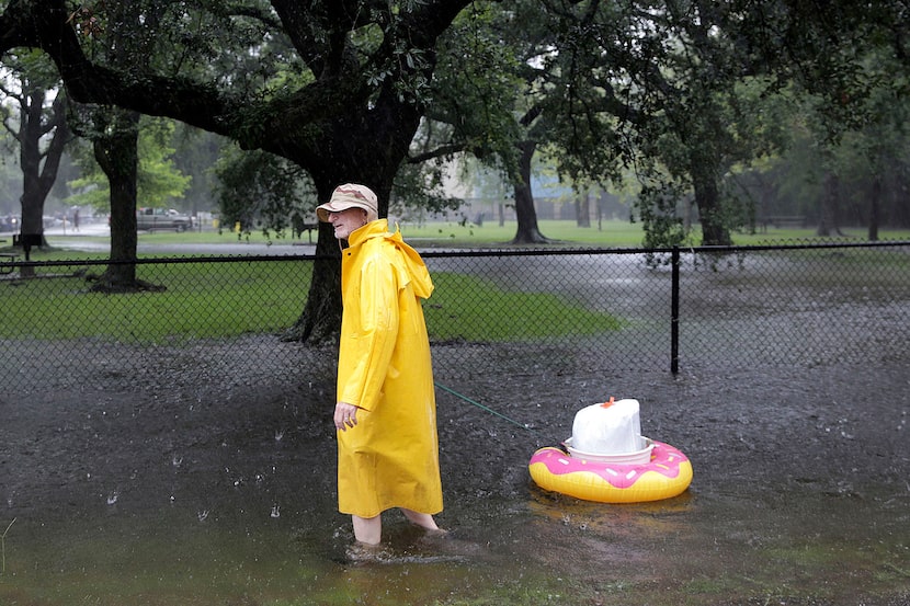 A man drags his belongings as he makes his way down a flooded street in the Melrose Park...