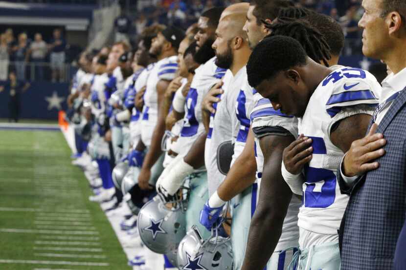 The Dallas Cowboys line up for the National Anthem before their game against the Houston...