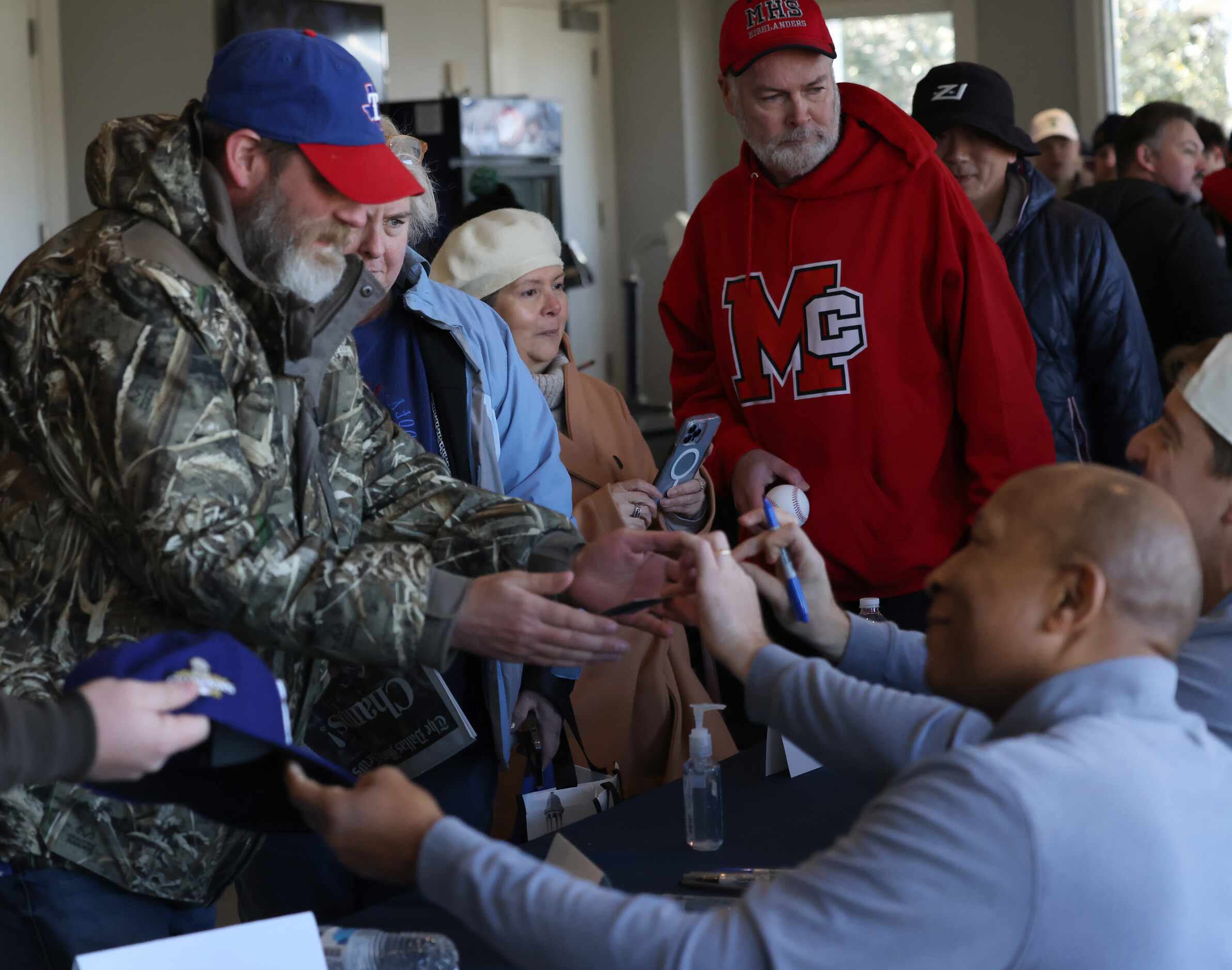 Texas Rangers fans receive autographs from Rangers assistant coach Tony Beasley, lower...