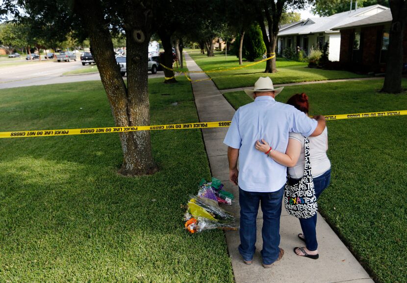 Hal Moss and daughter Kelsey Moss, of Plano, who knew three of the victims, place flowers...