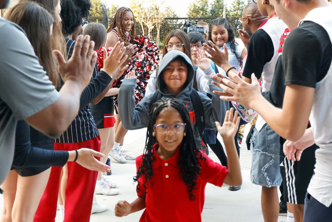 Students from John J. Pershing Elementary School give Hillcrest High School a high-five...