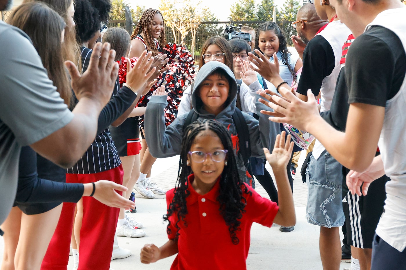 Students at John J. Pershing Elementary School high-five Hillcrest High School...