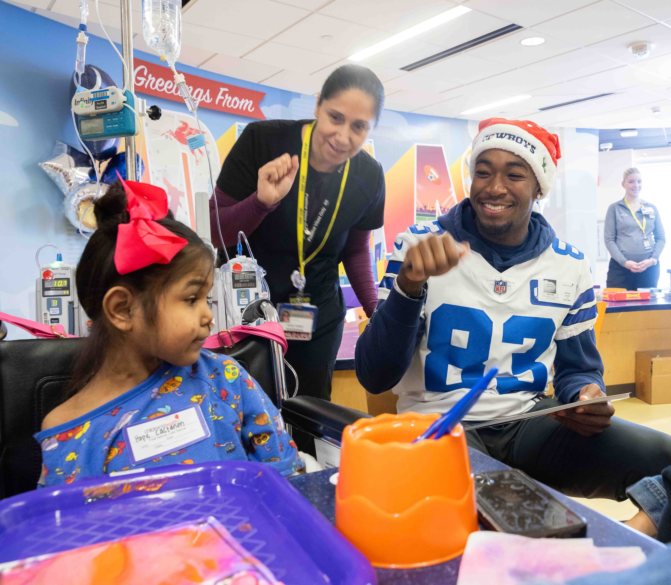 Child Life assistant Irene Gomez (second to left) and Dallas Cowboys wide receiver Jalen...