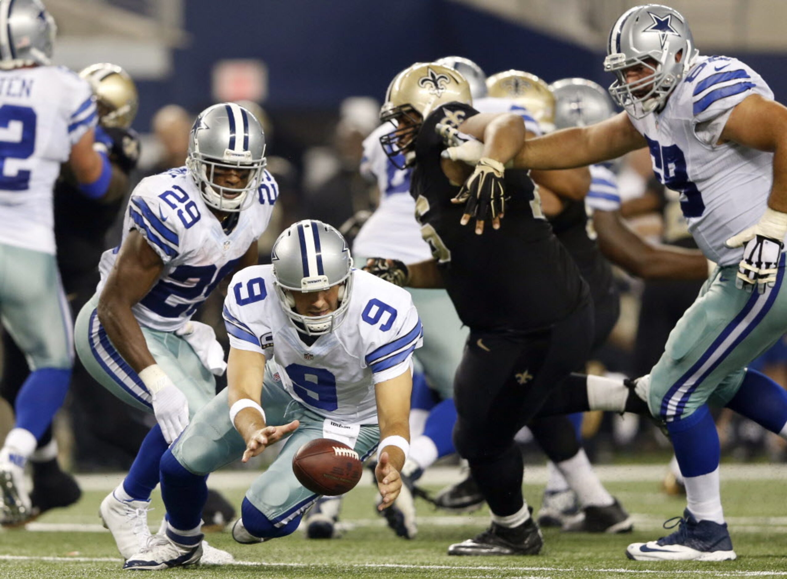 Dallas Cowboys quarterback Tony Romo (9) chases after a botched snap in a game against the...