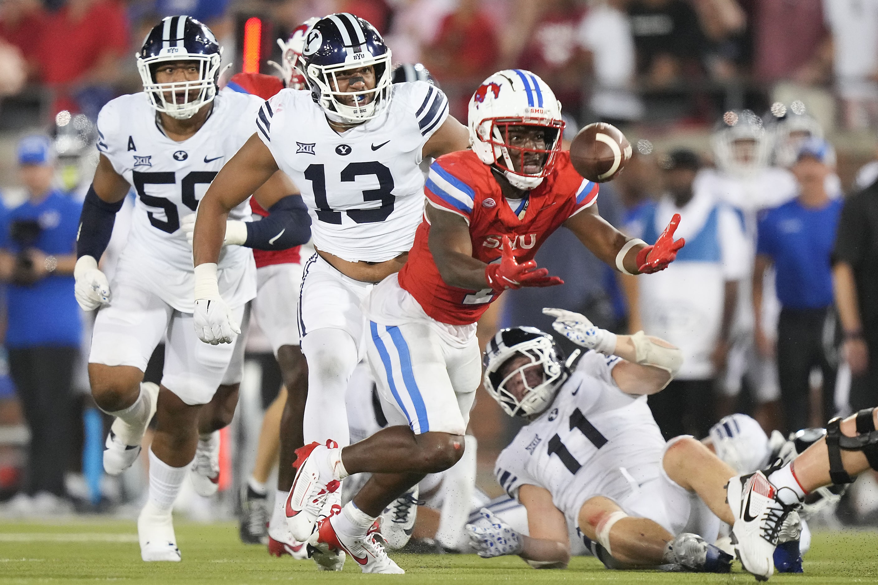 SMU running back Brashard Smith (1) bobbles the ball before recovering on a run past BYU...