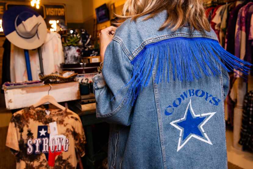Game Day Style founder Brittany Cobb models a jacket for a photo at her shop across from The...