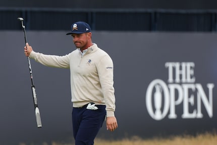 Bryson DeChambeau of the United States gestures to the crowd on the 18th green during his...