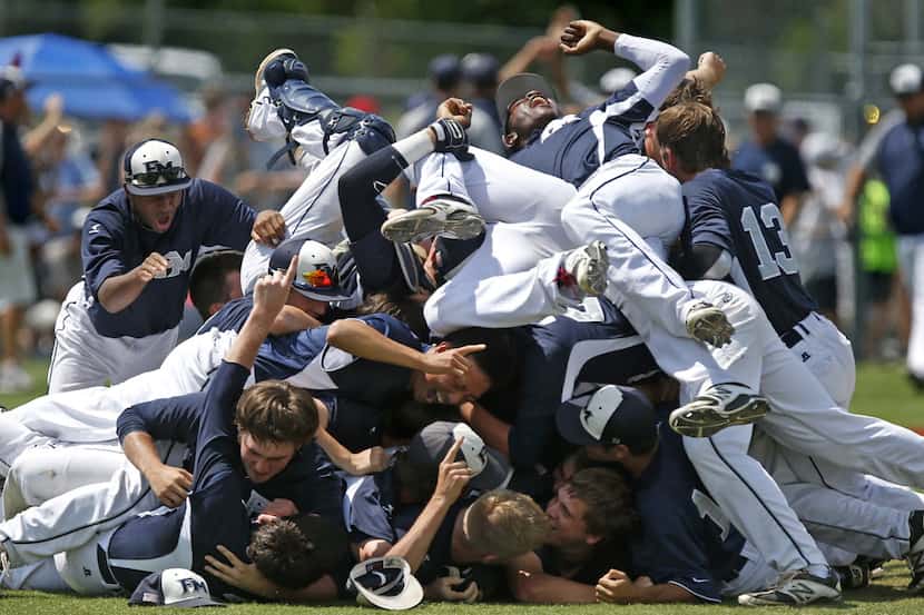 The Flower Mound High School baseball team piles ontop of each other in celebration after...