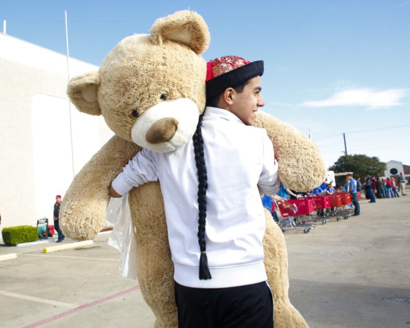 Eyad Alrabbat carried an oversized teddy bear to the toy donation collection room for the...