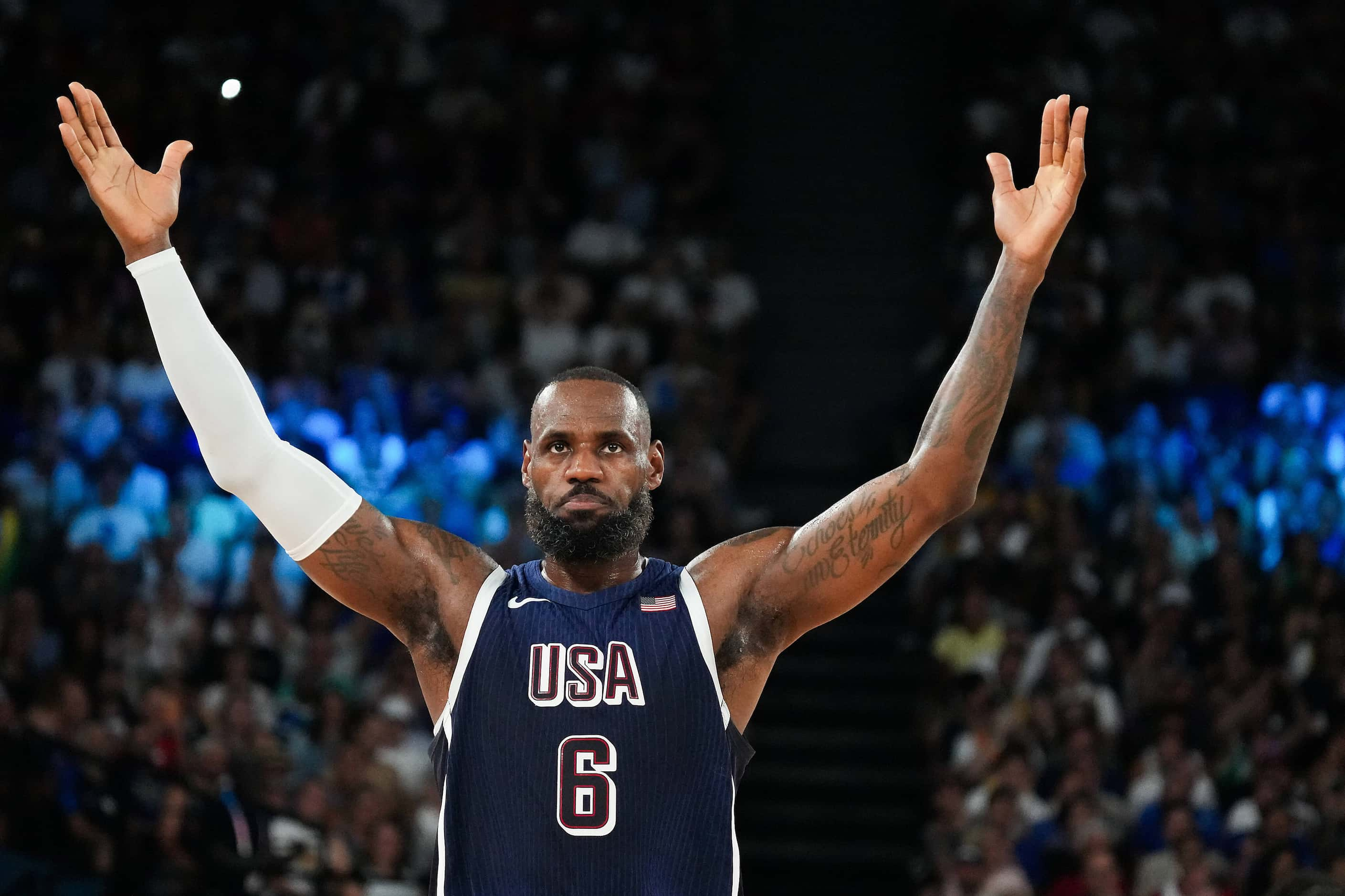 Lebron James of the United States encourages the crowd while they booed Joel Embiid during a...