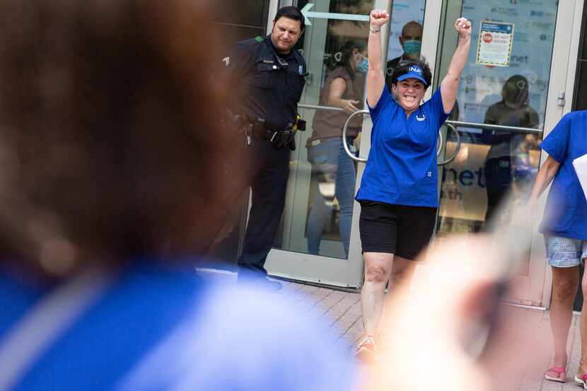 Striking nurse Marie Ritacco celebrates after delivering a petition signed by 700 nurses to...