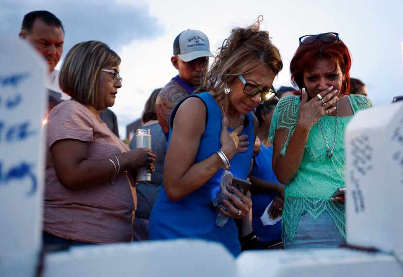 Rebecca Najera and Elsa Escobar of El Paso get emotional as they visit a makeshift memorial...