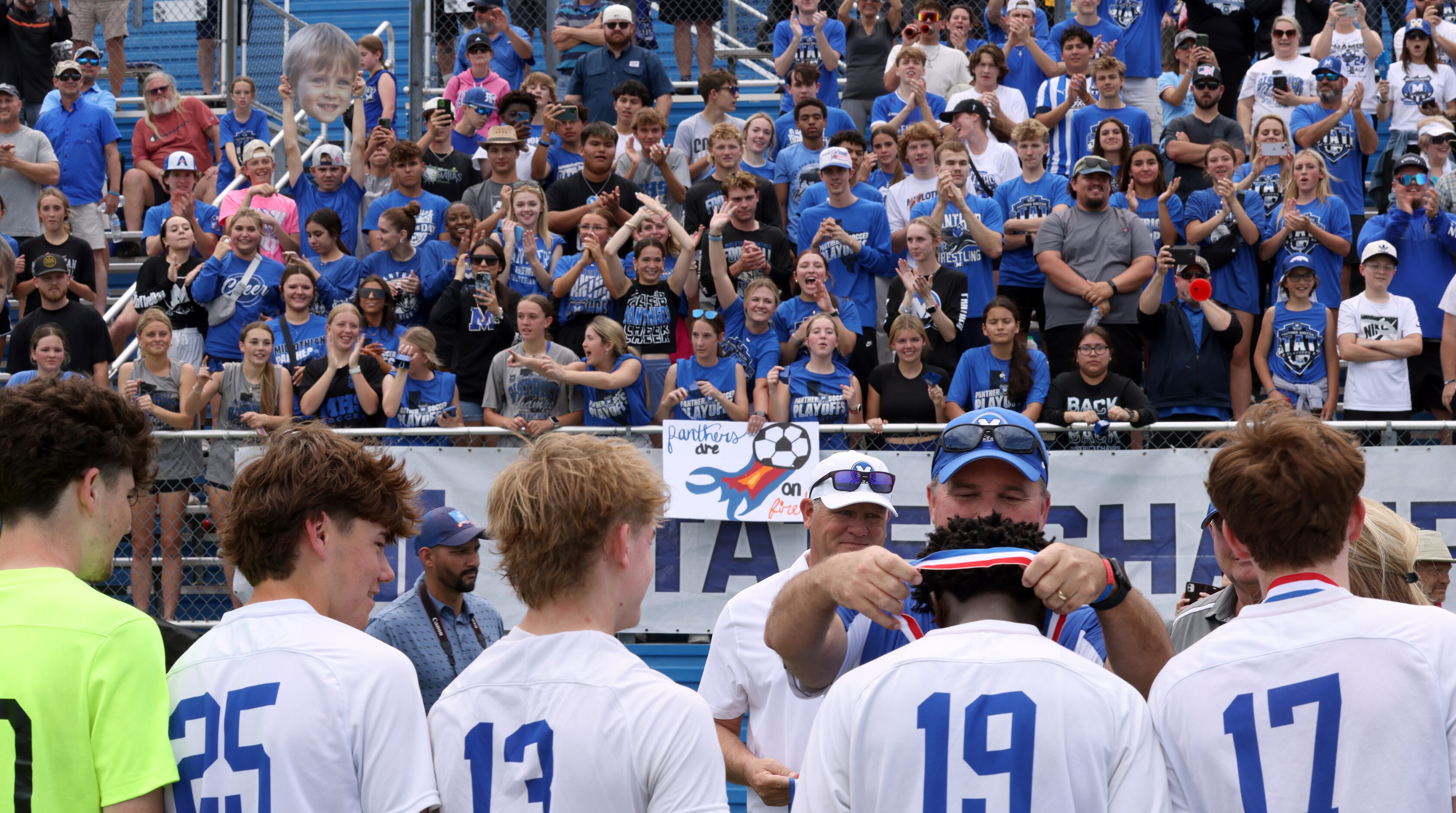 Midlothian fans voice their support as players on the field receive their medals after...